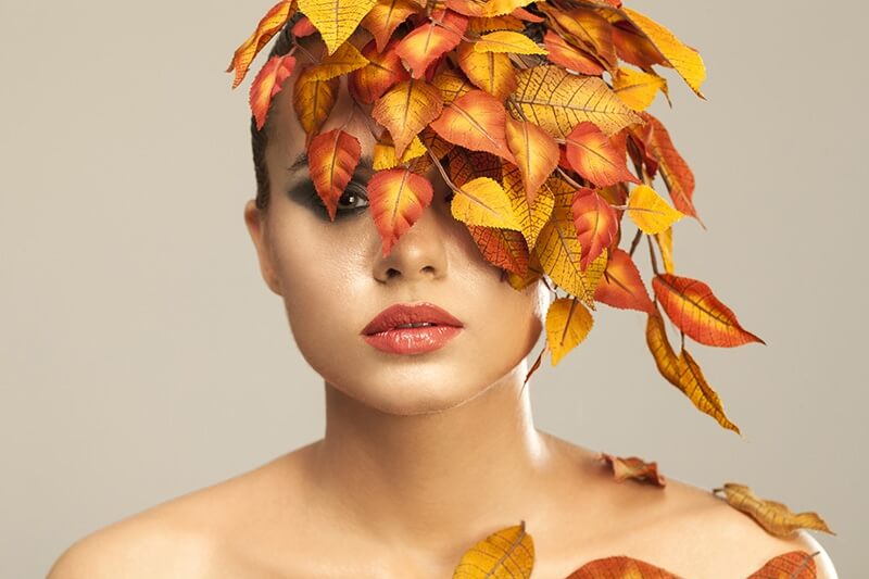 model covered with leaves portraying autumn