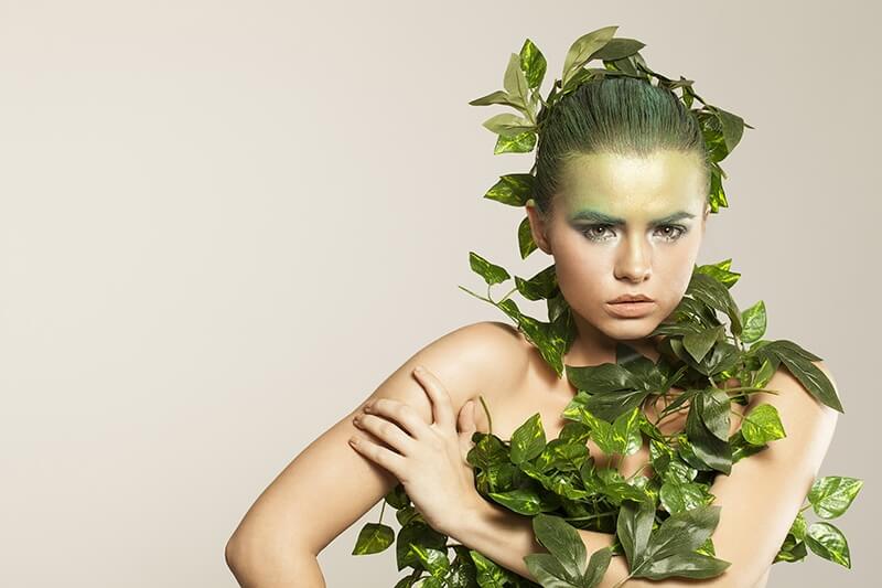 woman covered with green leaves