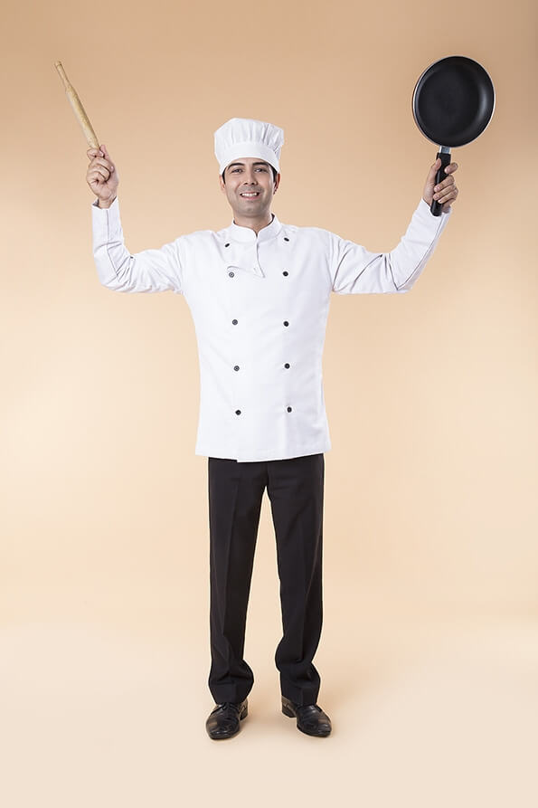 chef posing with rolling pin and frying pan