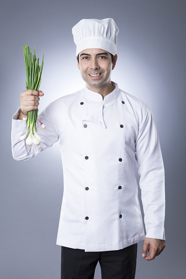 chef posing with spring onions 