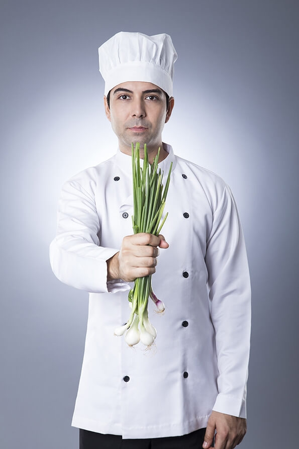chef posing with spring onions 
