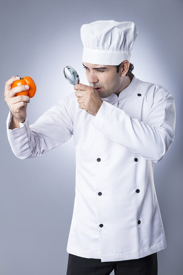 chef checking capsicum with magnifying glass 