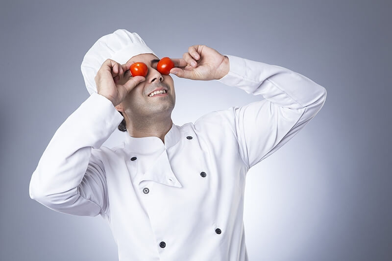 indian chef posing with tomatoes