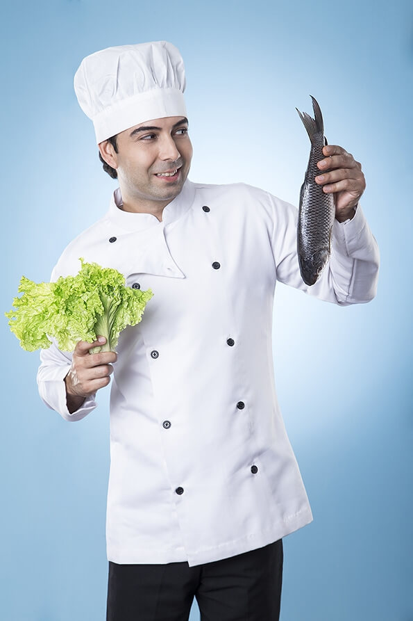 chef posing with fish and lettuce