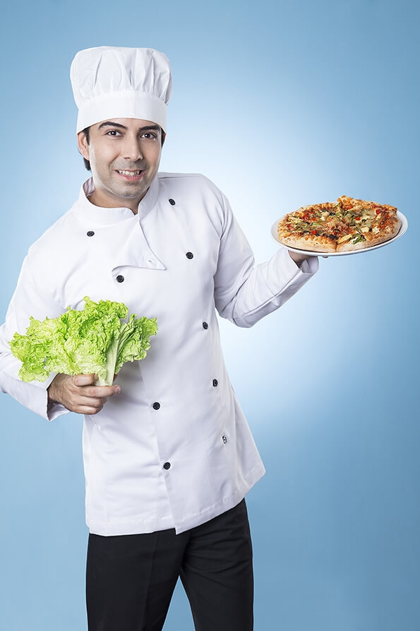 chef posing with pizza and lettuce