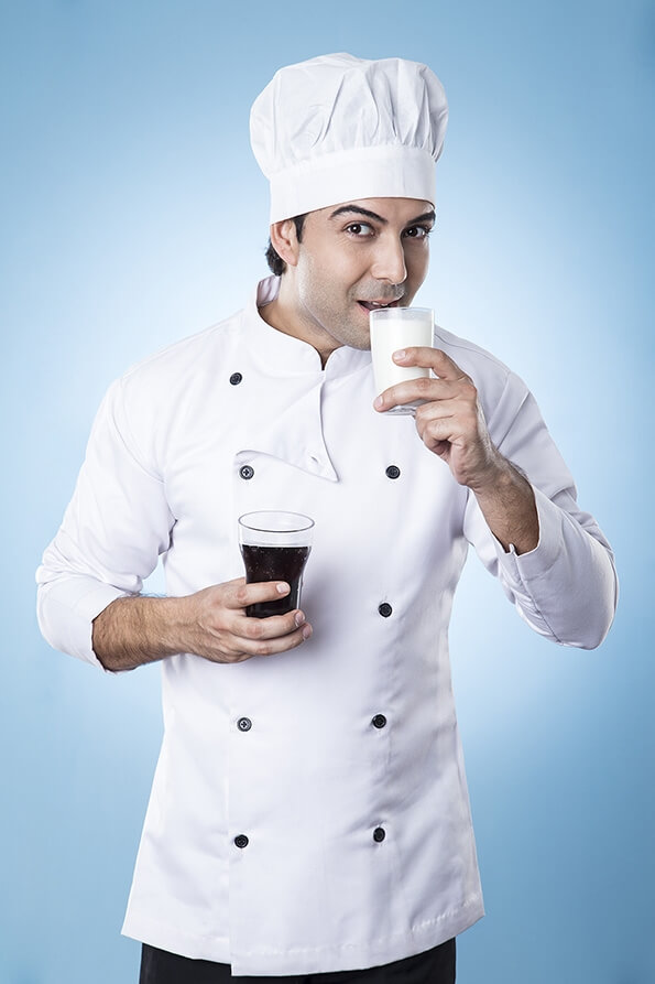 chef posing with glass of milk and soft drink