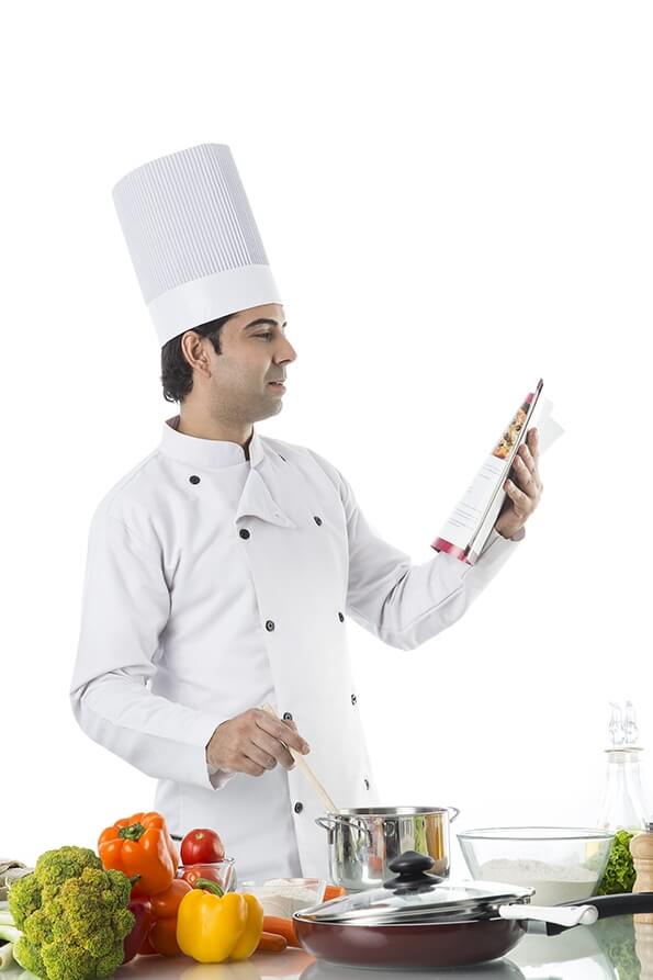 chef cooking with the help of recipe book 