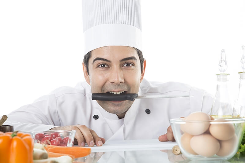 chef in kitchen posing with knife