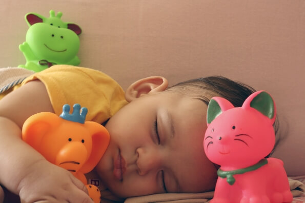 infant sleeping with toys 