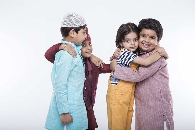 kids from different religions hugging each other 