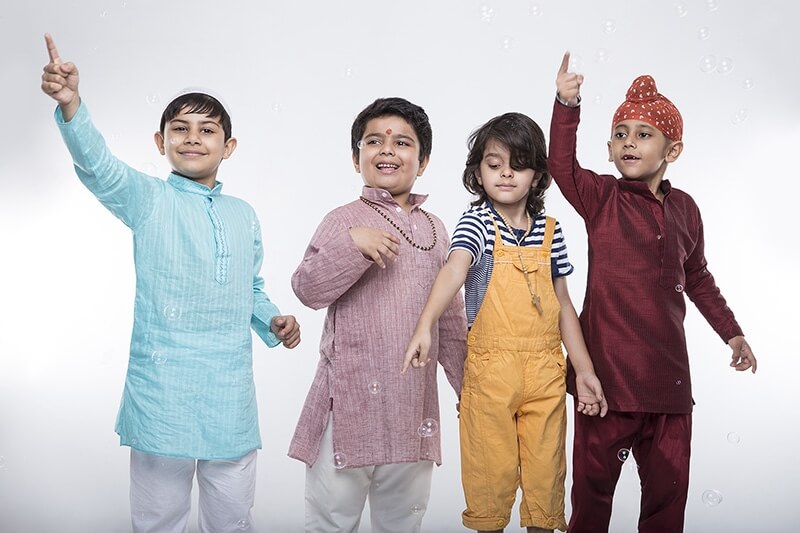 four kids from different religion playing with bubbles