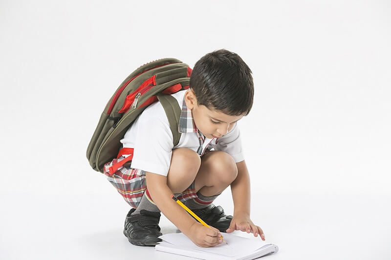 school kid in uniform doing homework