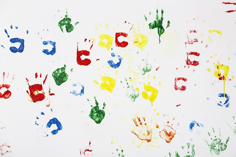 colourful hand prints on white wall background