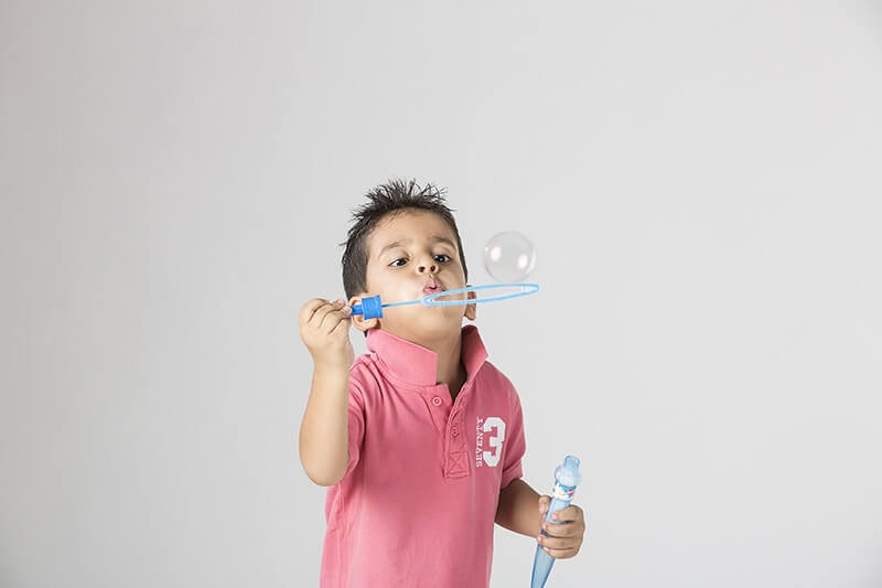 little boy playing with bubble toy