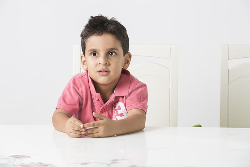 child sitting on chair at home