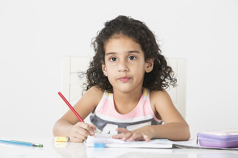 cute little girl studying on table