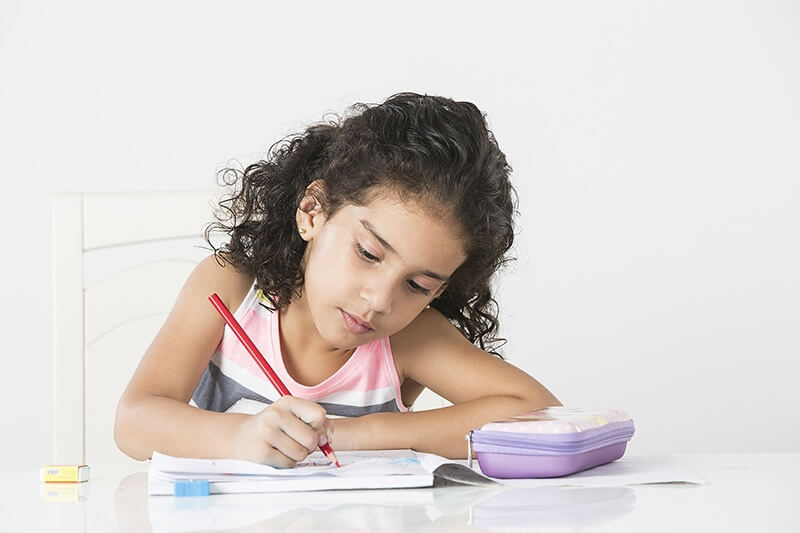 cute little girl studying on table