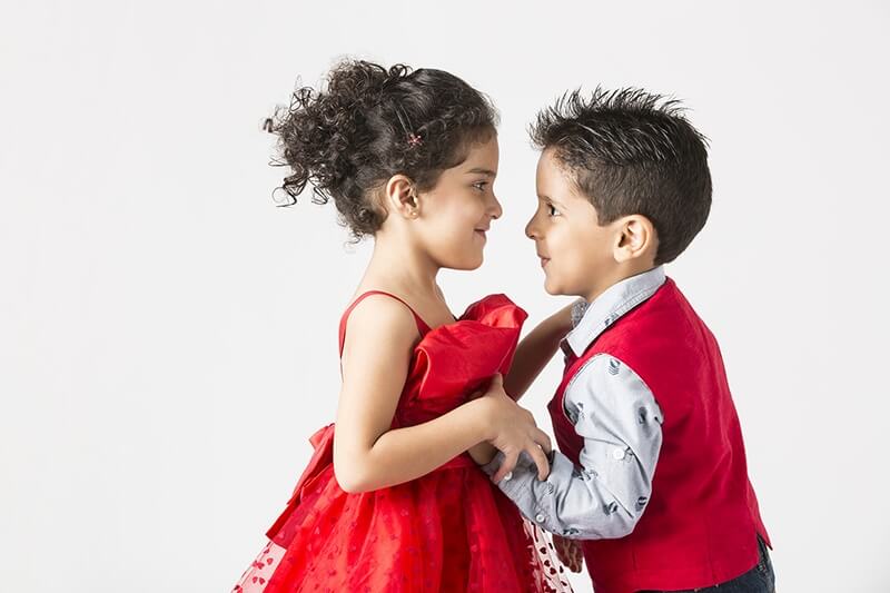 two cute little kids dancing while looking at each other