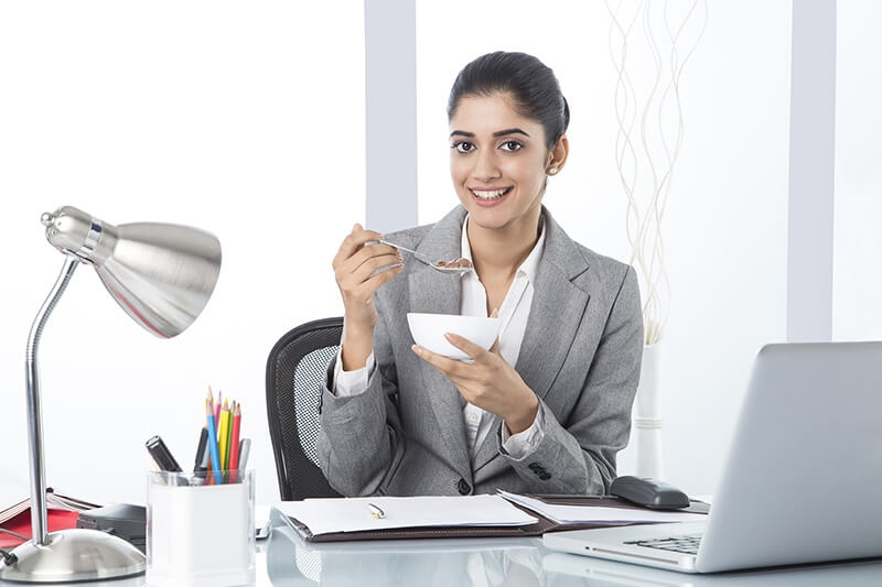 business woman eating cornflakes while working