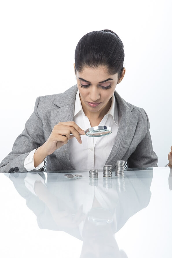 woman in formals checking money with magnifying glass