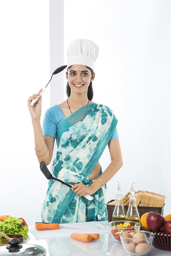 Indian housewife posing with spatula and ladle