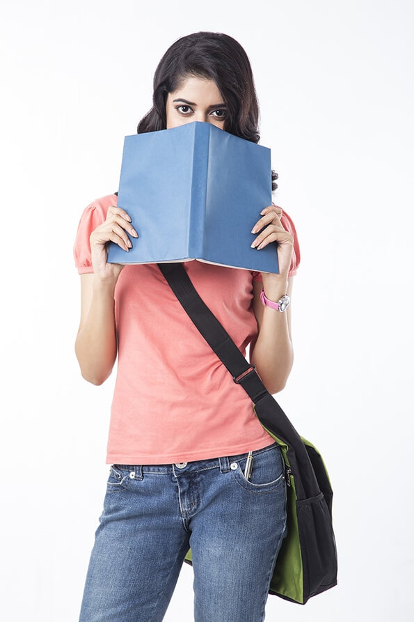 college girl hiding face with book