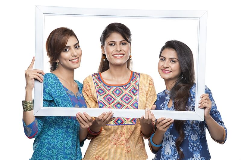 Three stylish woman looking through a frame