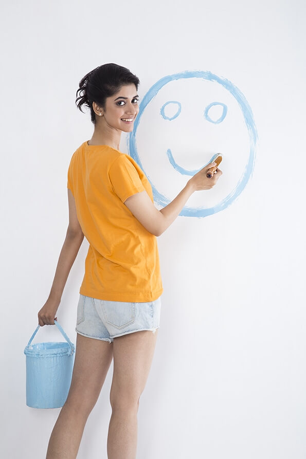 girl painting her wall at home