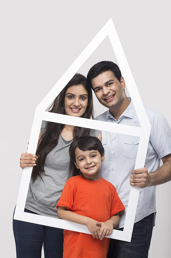 family posing with house shaped frame