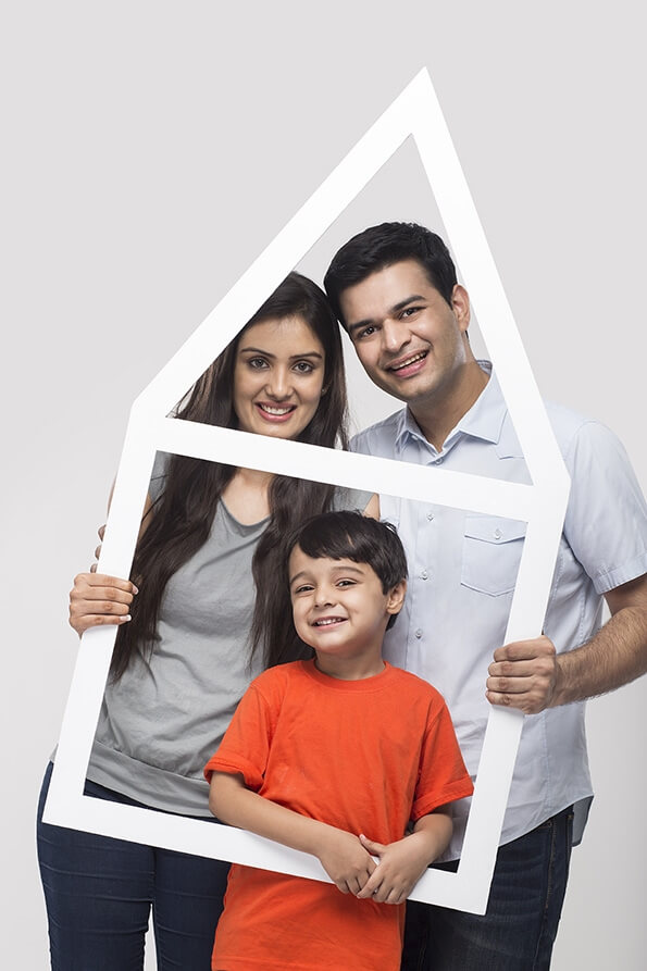 family posing with house shaped frame
