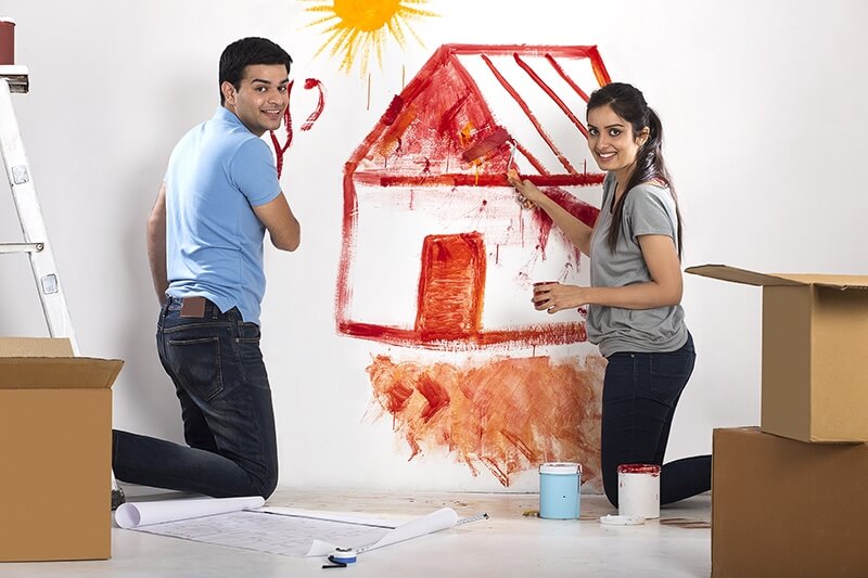 couple painting wall in new home
