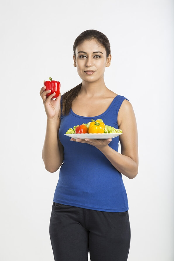 young woman red capsicum with full plate of vegetable