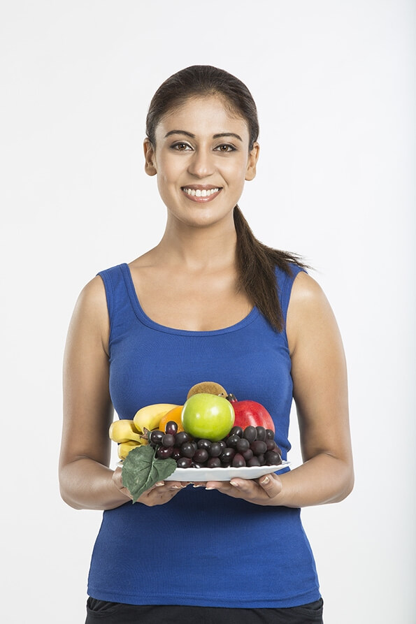 young woman with full plate of fruits