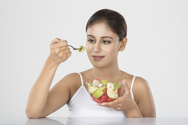 Girl posing with a bowl full of fruits salad