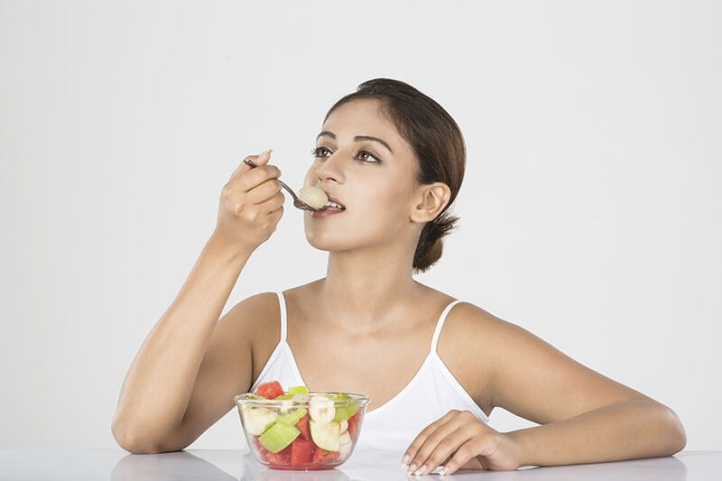 Girl posing with a bowl full of fruits salad