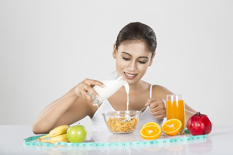 Young woman add milk in conflex healthy fruits & juice