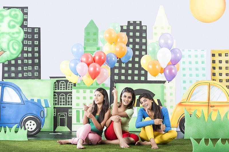 Three girls holding balloons