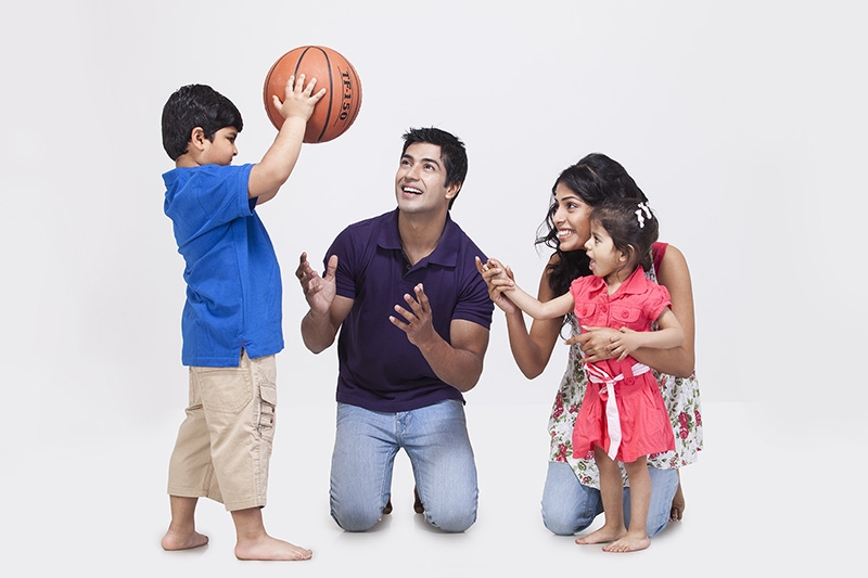 Boy playing with a ball with his family
