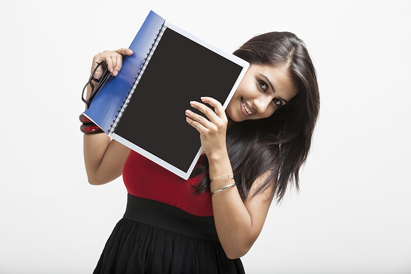 college girl posing while holding a text book